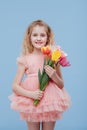 Tulips. little girl with spring flowers in her hand, in pink dress