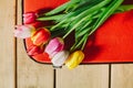 Tulips in red suitcase. wooden background