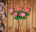 Tulips on sticks on a wooden background