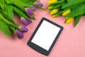Tulips and tablet with white mockup screen on pink background. Greeting card for Easter or Women`s Day Royalty Free Stock Photo