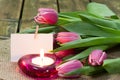 Tulips in vase and burning candle Royalty Free Stock Photo