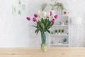 Tulips in a vase on a wooden table. Scandinavian interior Royalty Free Stock Photo