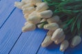 Tulips white-biege bouquet on bgrunge wooden background, close-up. Royalty Free Stock Photo
