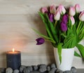 Tulips in a white vase with burning candle Royalty Free Stock Photo