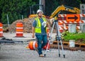 Surveyer calling out to someone on construction site with book in his hand by tripod with Optical Leve Royalty Free Stock Photo