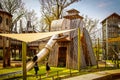 Wooden Elephant Climbing castle with slide for trunk and sail awning with children playing in Springtime