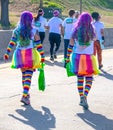 4-6-2019 Tulsa - Two women participating in the Tulsa Color Run walk away from camera with long rainbow colored hair, rainbow