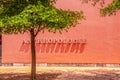 Anthropologie Store sign on orange wall with shodows and tree by sidewalk