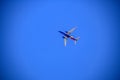 Colorful Southwestern airplane flying through very blue cloudless sky - view from below - room for copy