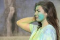 4-6-2019 Tulsa USA Girl with colored powder on her face and all over her and a funny frown pushes back her long hair against