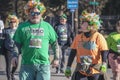 3-16-2019 Tulsa USA - MIddle aged man and woman couple with feather wigs and OSCSO teeshirts walk and chat in St Patricks Day