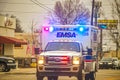 2-1-2019 Tulsa USA - Oncoming EMSA ambulance with lights blazing on urban street on overcast day - selective focus