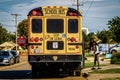 Stopped School bus with blinking lights and stop sign extended picks up black student near Democratic