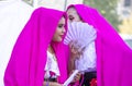 Tulsa USA - Two beautiful young girls gossip behind a hand fan as they prepare to dance in costume at a Latin