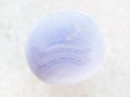 tumbled blue chalcedony gemstone on white marble