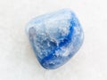 tumbled blue dyed agate gemstone on white marble Royalty Free Stock Photo