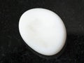 tumbled cacholong (white opal) gemstone on dark