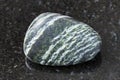 tumbled Chrysotile asbestos gemstone on dark