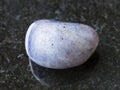 tumbled Cordierite gemstone on dark background