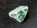 tumbled green Grossular gemstone on dark