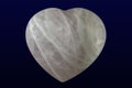 Tumbled and polished rose quartz heart on dark background