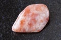 tumbled sunstone (heliolite) gemstone on dark