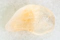 tumbled yellow Citrine gemstone on white marble