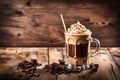 The tumbler of iced coffee with whipping cream on top. Cool summer beverage on a wooden backdrop Royalty Free Stock Photo