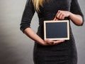 Woman holding blank black board on stomach