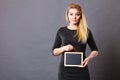 Woman holding blank black board on stomach