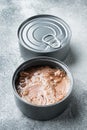 Tuna in a can, whole and chopped, in tin can, on gray background Royalty Free Stock Photo