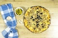 tuna pizza with cheese and tomato and olives on cutting wooden board with green olive bowl and garlic. Royalty Free Stock Photo