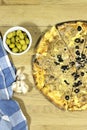 tuna pizza with cheese and tomato and olives with green olive bowl and garlic on wood table Royalty Free Stock Photo