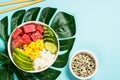 Tuna poke bowl with rice, avocado, mango and cucumber on blue. Royalty Free Stock Photo