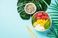 Tuna poke bowl with rice, avocado, mango and cucumber on blue. Royalty Free Stock Photo