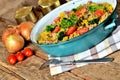 Tuna risotto with vegetables, tomatoes, broccoli and parsley in the old pan, onions, cans and oil in the background Royalty Free Stock Photo