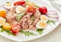 Tuna salad with arugula and tomatoes on light wooden background. Healthy food, seafood menu Royalty Free Stock Photo