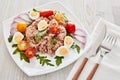 Tuna salad with arugula and tomatoes on light wooden background. Healthy food, seafood menu Royalty Free Stock Photo