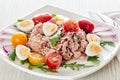 Tuna salad with arugula and tomatoes on light wooden background. Healthy food, seafood menu Royalty Free Stock Photo