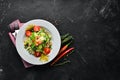 Tuna salad and fresh vegetables on a black background. Free space for your text. Royalty Free Stock Photo