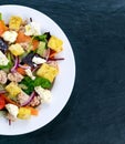 Tuna salad with vegetables on blue stone background