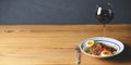 Tuna salad with vegetables, boiled eggs, cherry tomatoes and spices and one glass of red wine over wooden background Royalty Free Stock Photo