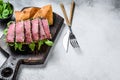 Tuna steak sandwich in a baguette with arugula. White background. Top view. Copy space Royalty Free Stock Photo