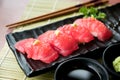 Tuna sushi on black plate along with Japanese sauce and green leaf decoration, Japanese food, close up at sushi Royalty Free Stock Photo