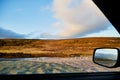 Tundra landscape with moss, glass and stouns in the north of Norway or Russia and blue sky with clouds frought window of a car