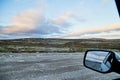 Tundra landscape with moss, glass and stouns in the north of Norway or Russia and blue sky with clouds frought window of a car