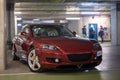 tuned maroon red Mazda RX8 in the dark garage