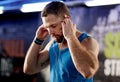 Tunes to train to. a young man listening to music during his workout at the gym. Royalty Free Stock Photo