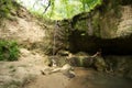 Young woman enjoys a summer day by a waterfall at Clark Creek Natural Area