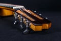 Tuning pegs on wooden machine head of six strings acoustic guitar neck on black background Royalty Free Stock Photo